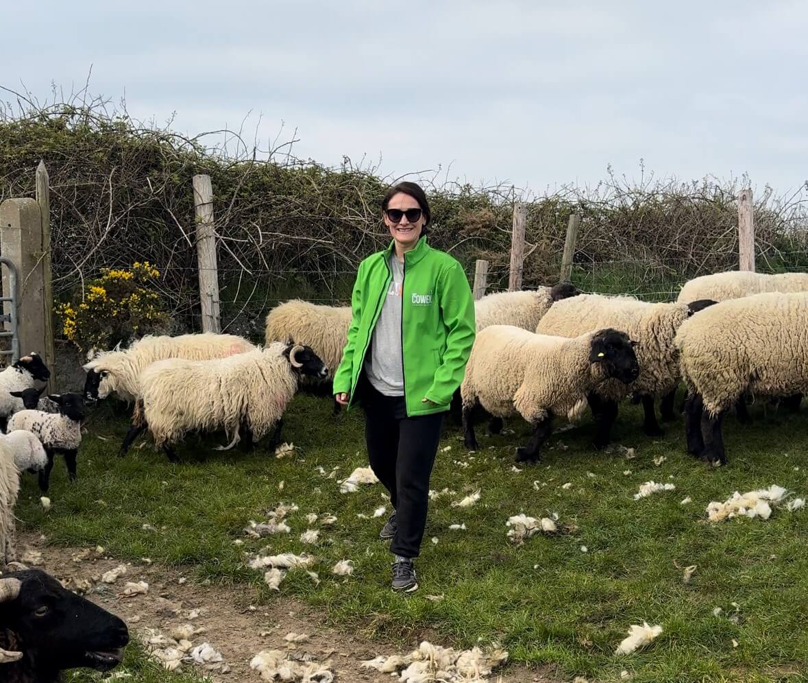 Senator Erin McGreehan with a green jacket black trousers with sheep in the background